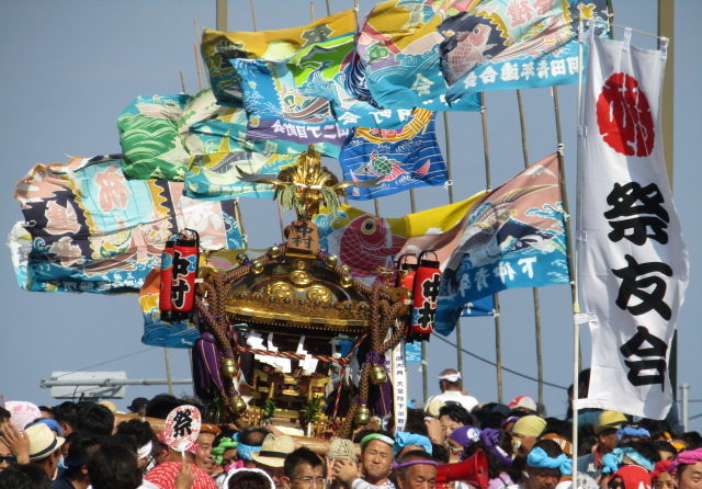 羽田神社例大祭で弁天橋を渡るお神輿と大漁旗です。
